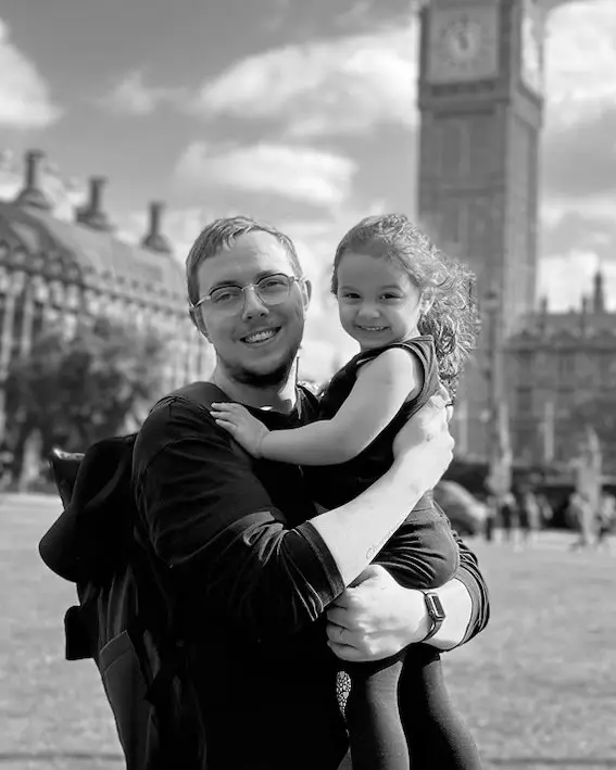 Michael Andersen in London, holding a child, with Big Ben behind them